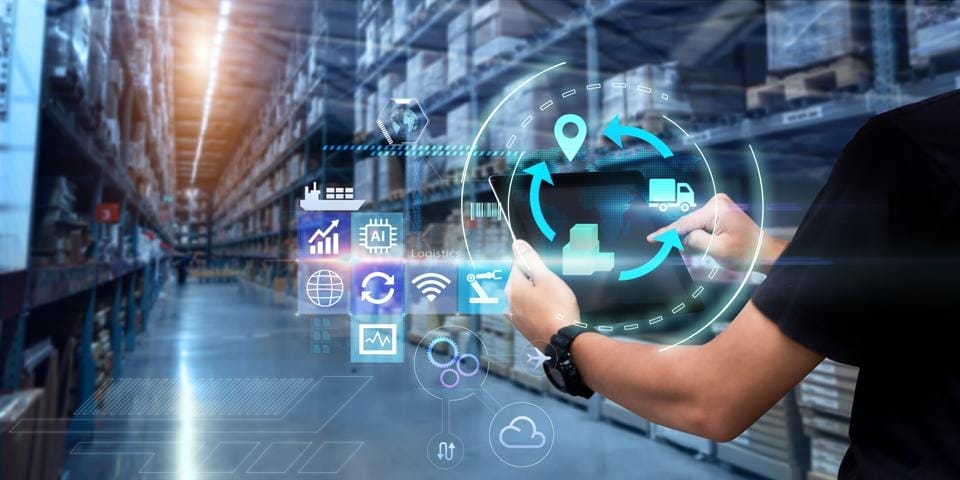 Person using a tablet with logistics and technology icons in the foreground, inside a warehouse with stacked shelves.