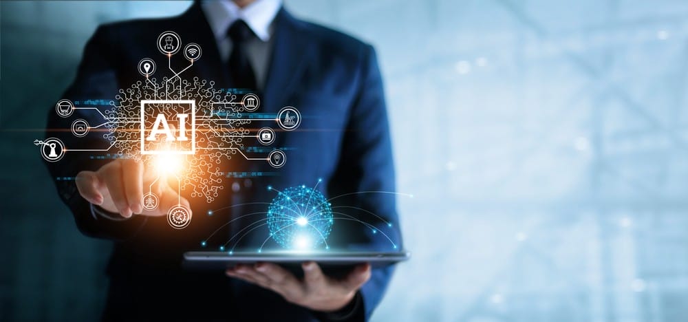 A person in a suit interacts with a virtual AI interface while holding a tablet, with digital graphics representing artificial intelligence and technology.